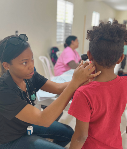 pre-med student examining a child and gaining hands on experience developing clinical skills on a medical internship abroad