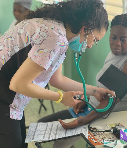 student intern taking vitals of patient premed student intern taking vitals of patient during their medical research internship abroad